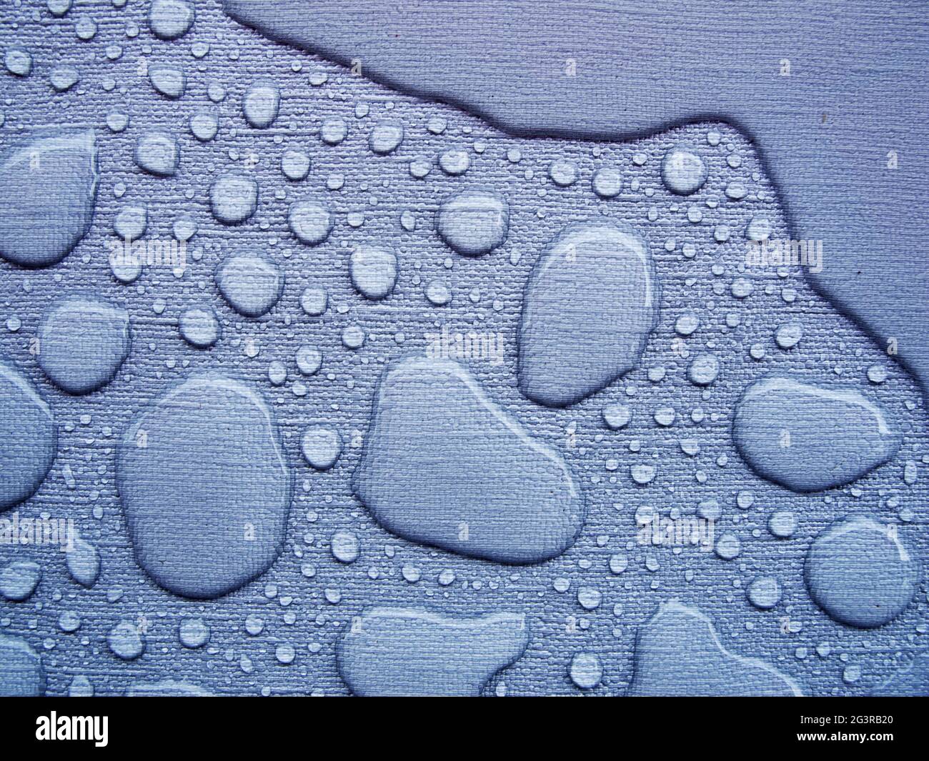 Gocce di pioggia su una tovaglia blu vicino Foto Stock