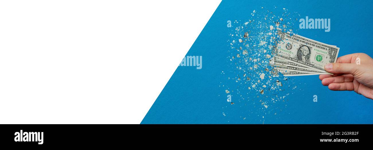 Inflazione, dollaro iper inflazione. Banner con sfondo blu. Una fattura del dollaro è spruzzata nella mano di un uomo su uno sfondo blu. Prezzo aumento conce Foto Stock