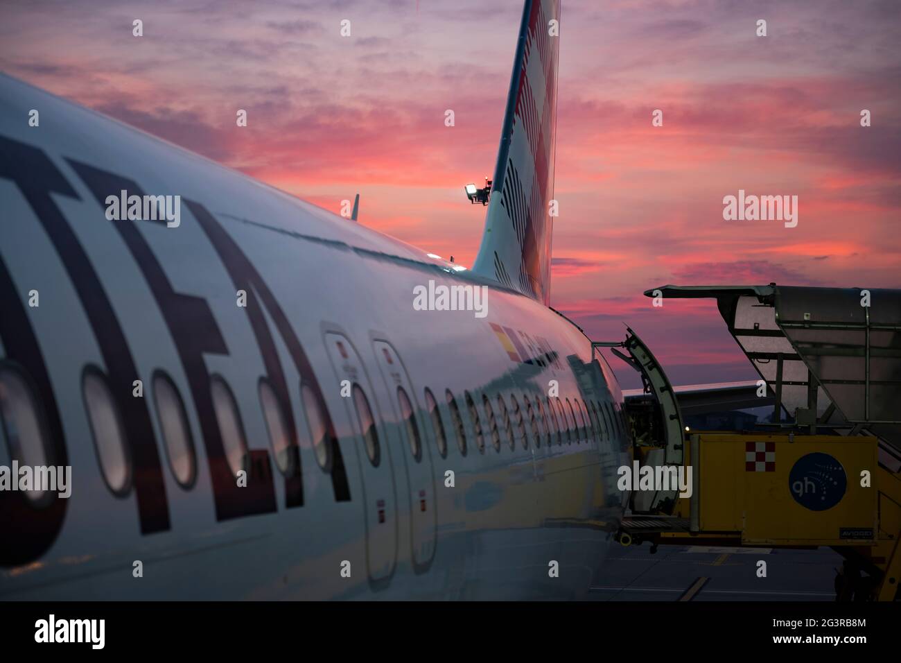 Aereo commerciale pronto ad imbarcarsi sui passeggeri dall'aeroporto di Verona durante un tramonto mozzafiato. Foto Stock