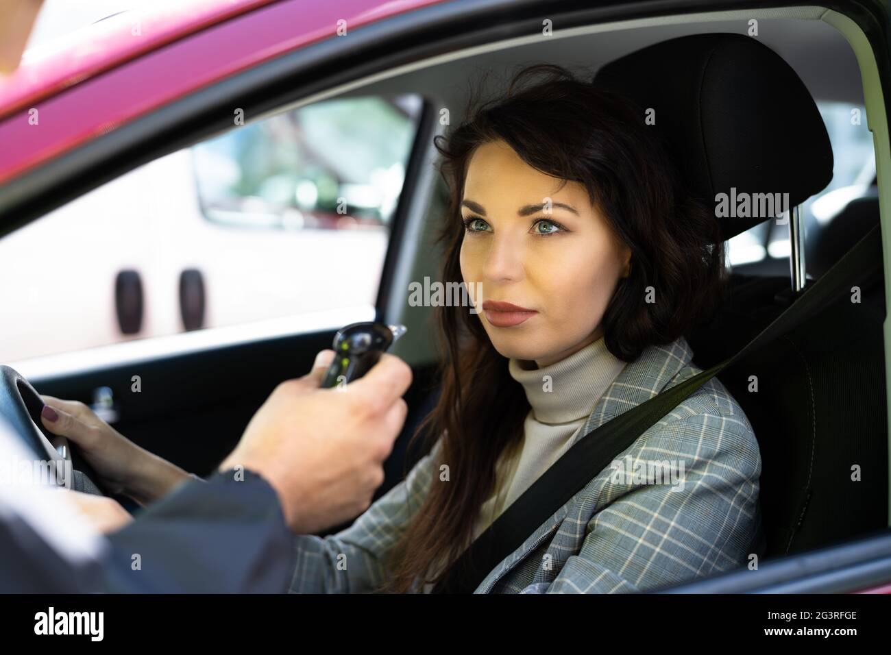 Poliziotto che fa test dell'alcool del driver usando Breathalyzer Foto Stock