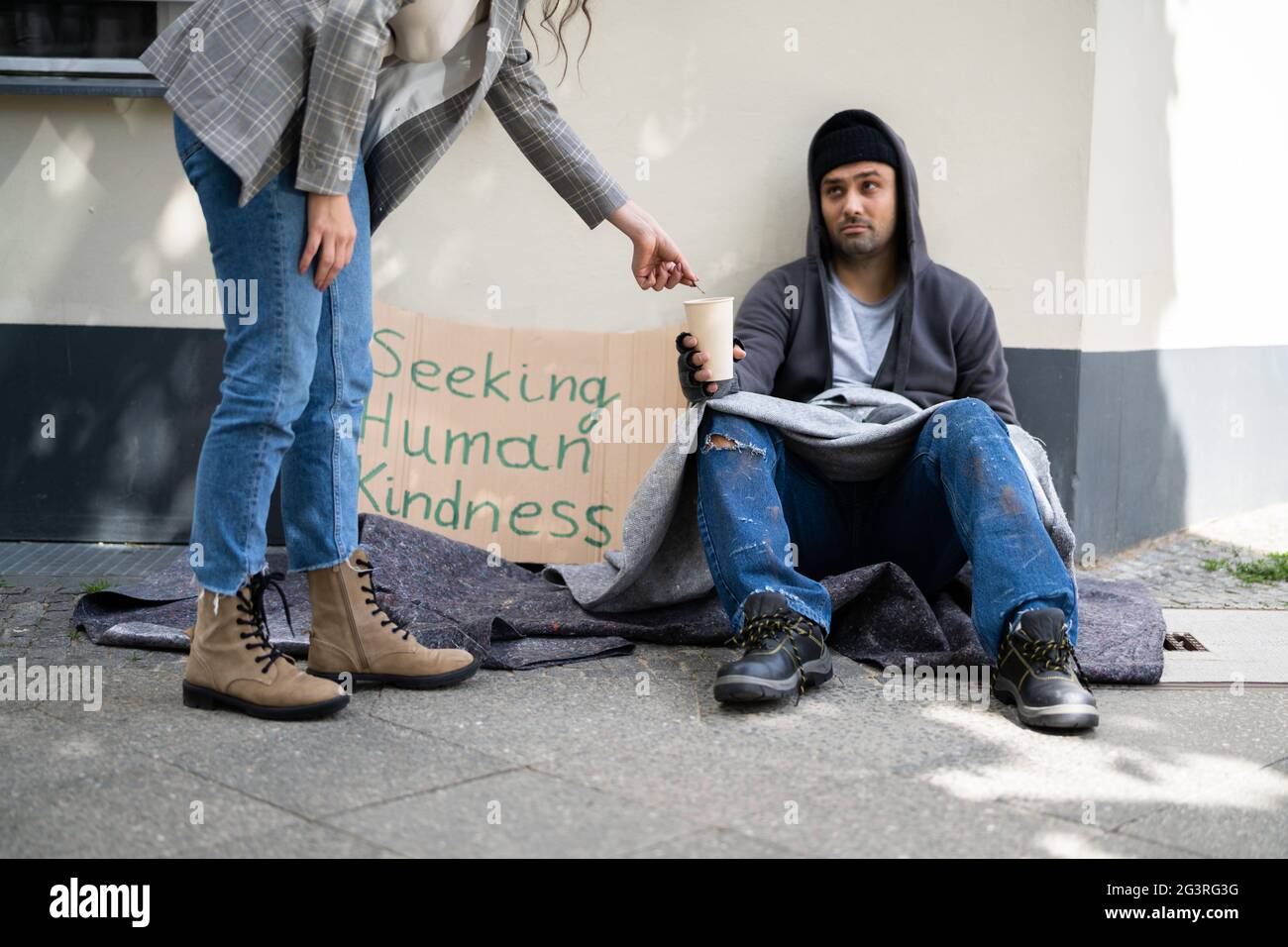 Moneta Money Aiuto per Beggar persona su strada Foto Stock