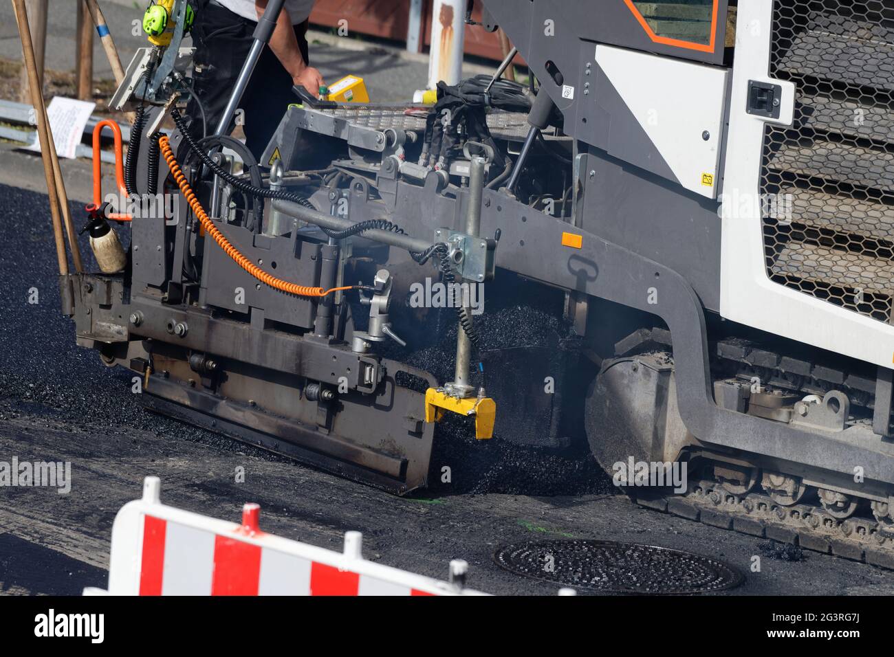 Asfaltatrice che finice una superficie stradale Foto Stock