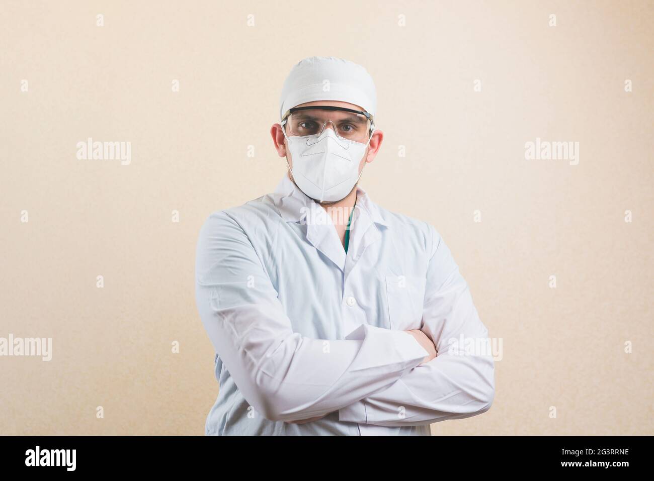 Ritratto medico in tuta bianca, occhiali protettivi e maschera protettiva con le mani sul petto sullo sfondo giallo isolato. Foto Stock