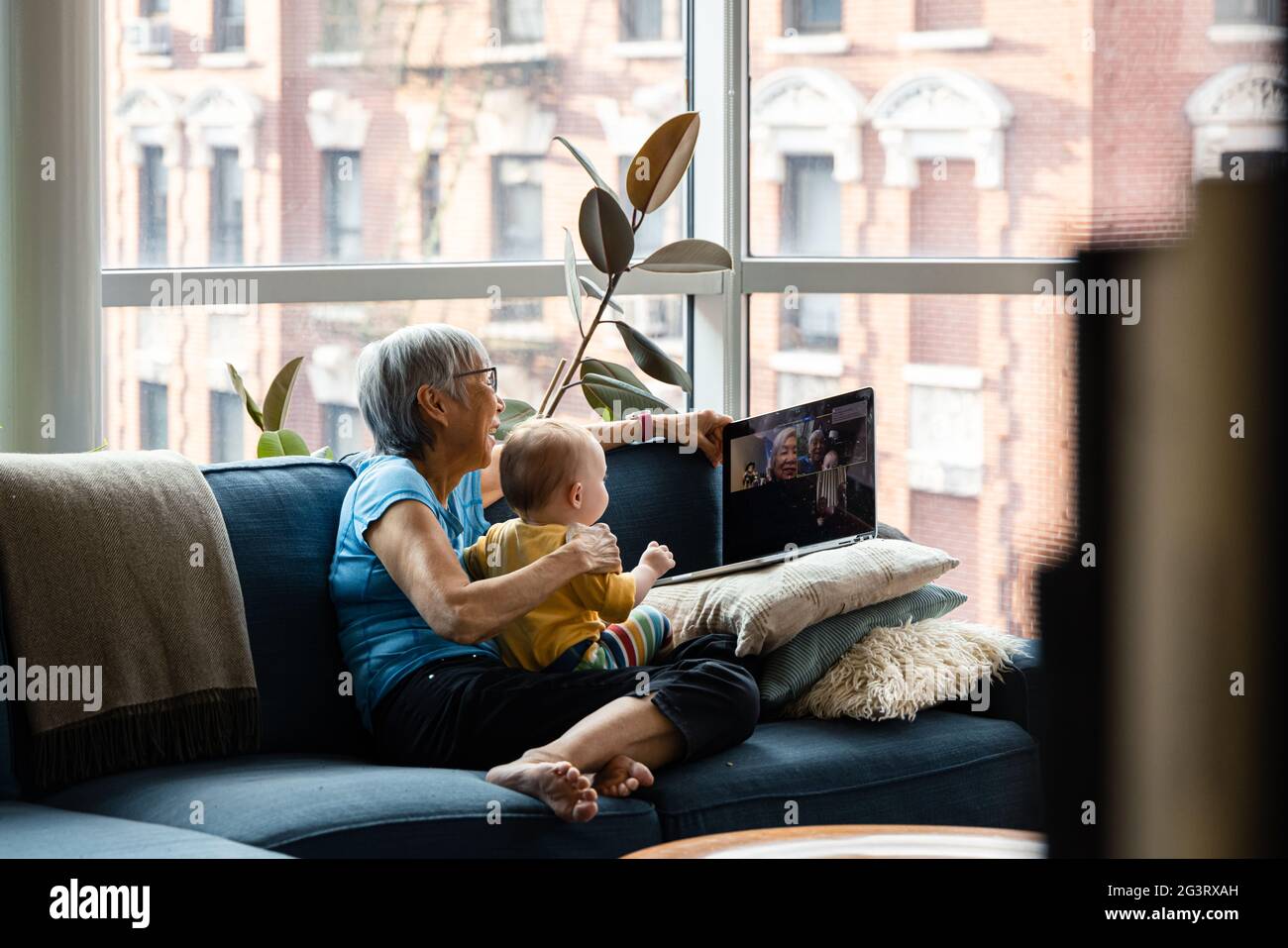Nonna e grandaughter che usano il laptop per videochattare con i parenti Foto Stock