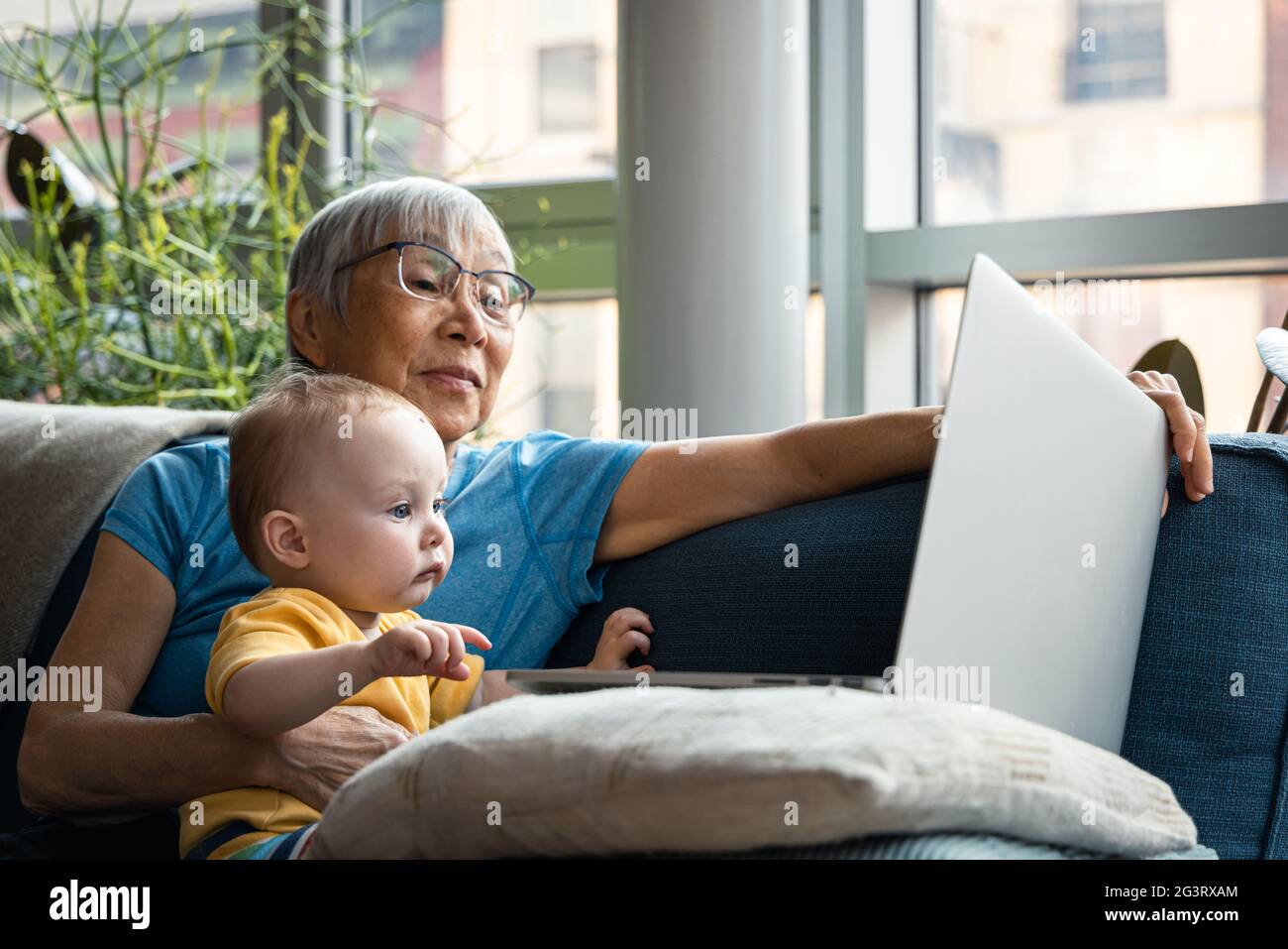 Nonno senior e nipote che guardano insieme il computer Foto Stock