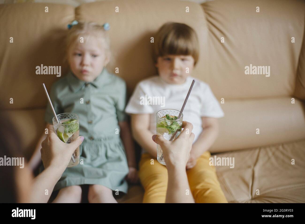 Donna che tiene fuori i cocktail con le padelle riutilizzabili ai bambini Foto Stock