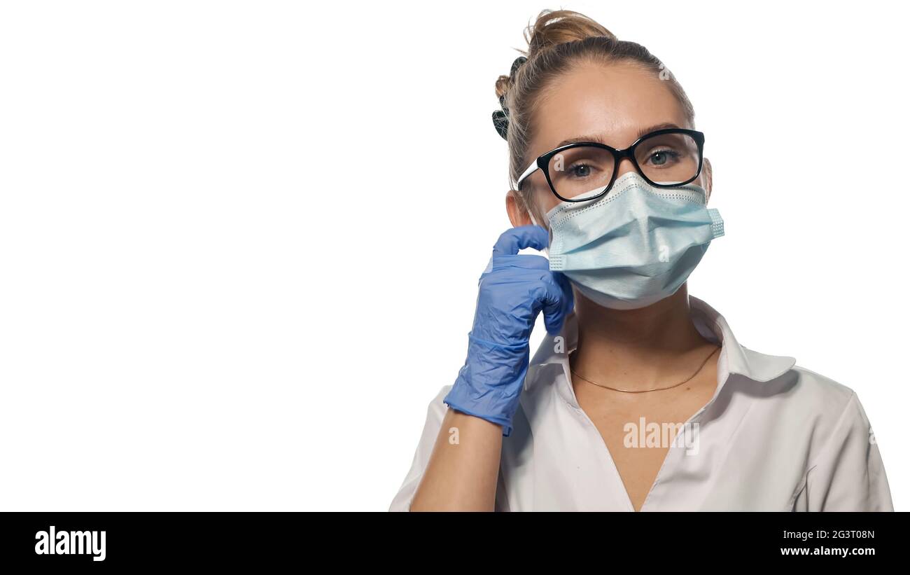 Giovane medico che fissa la sua maschera. Foto Stock