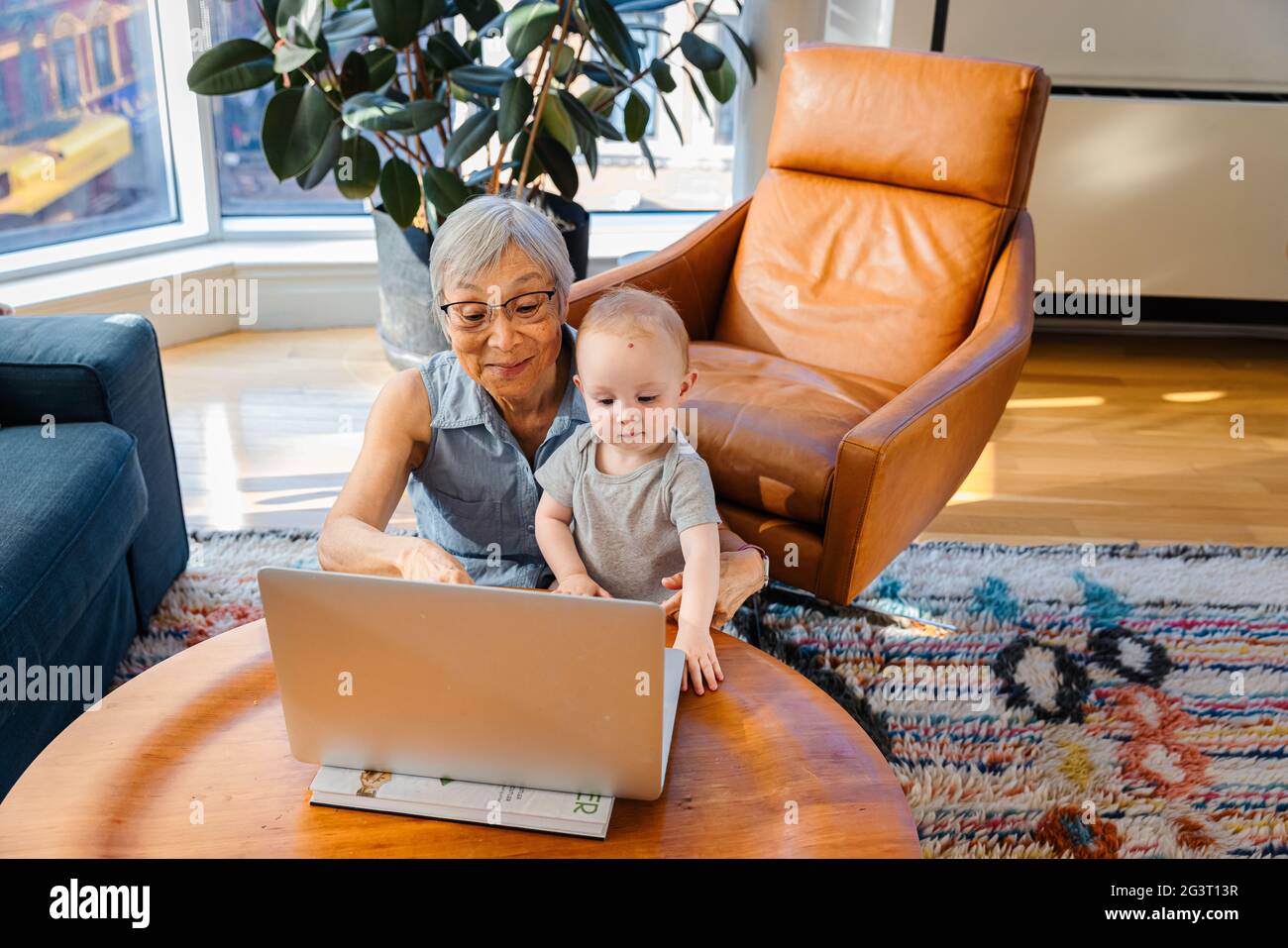 Donna anziana seduta con la nipote che effettua una videochiamata sul computer portatile Foto Stock