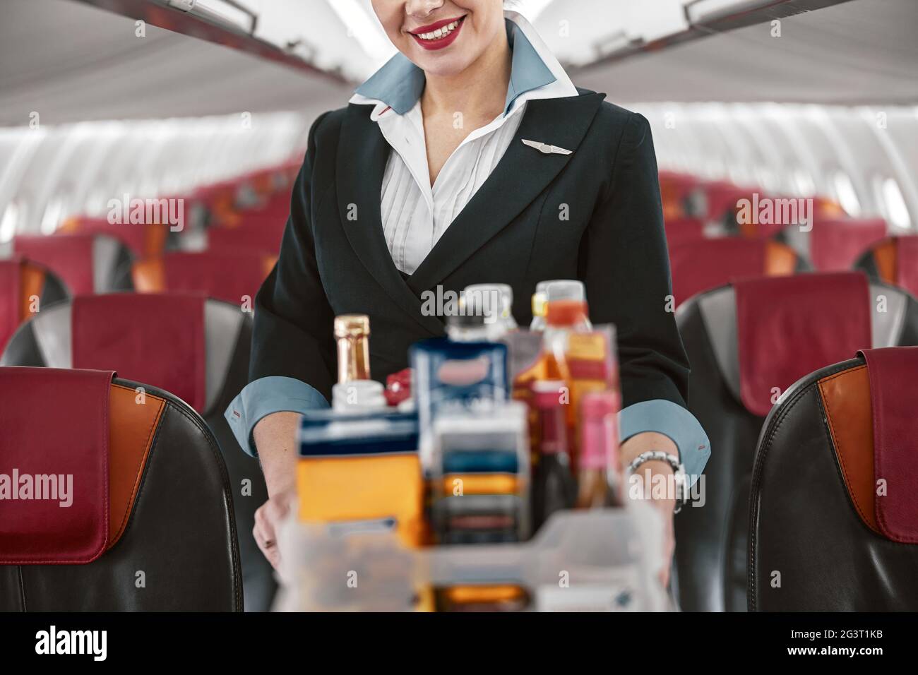 Stewardess con carrello di cibo in cabina dell'aeroplano Foto Stock