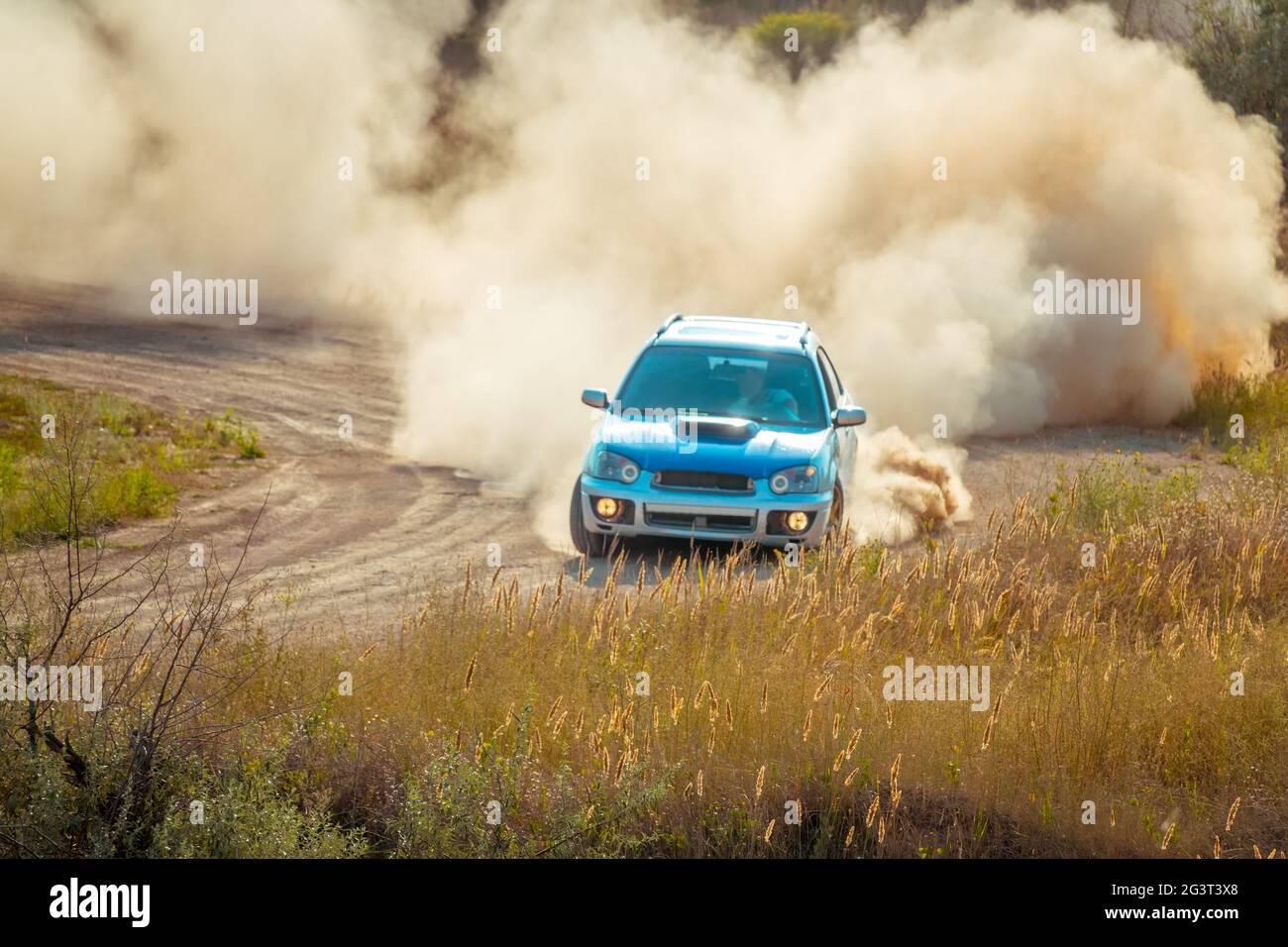 Auto sul Bend di una Sunny Dusty Road Foto Stock