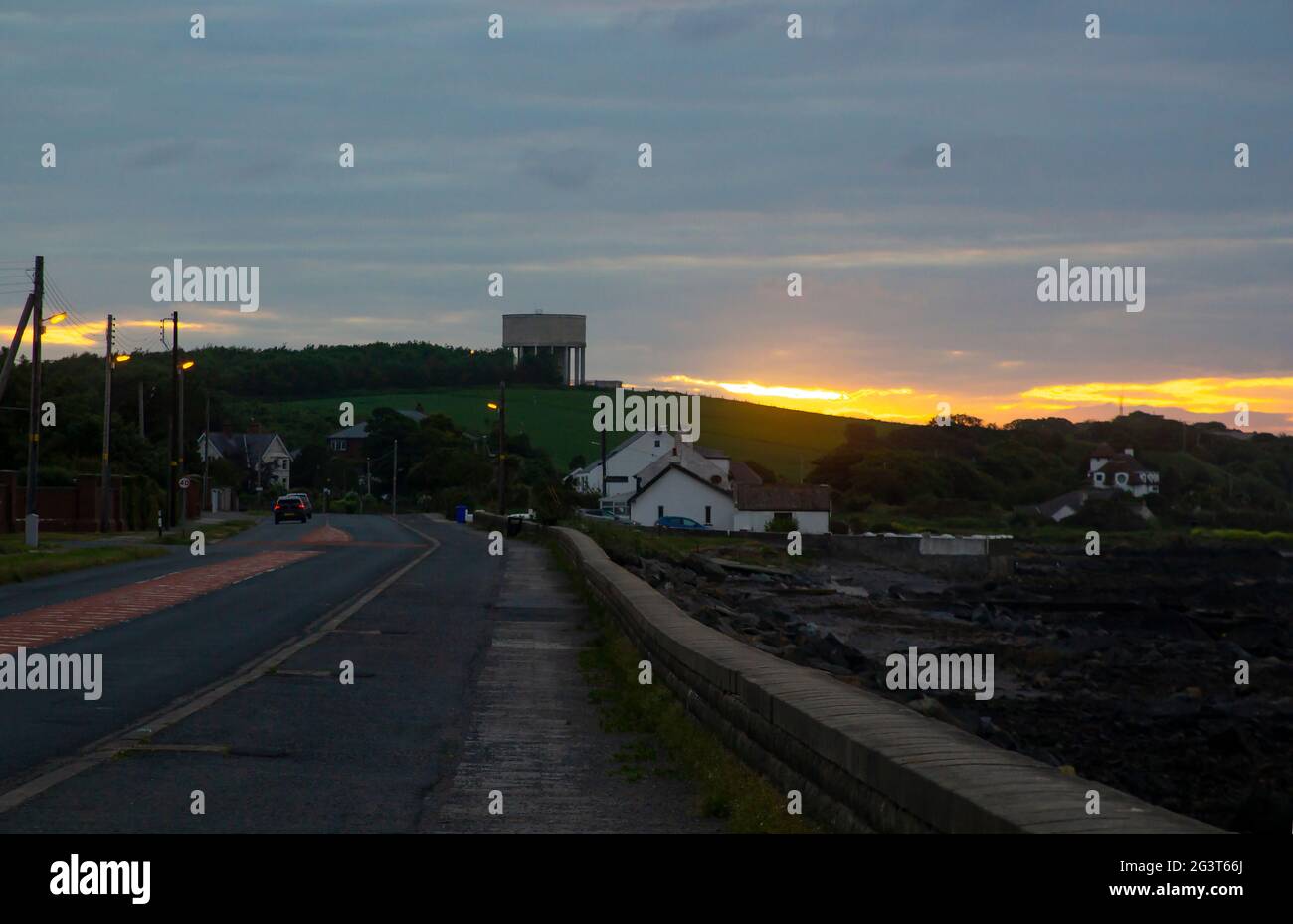 15 giugno 2021 immagine atmosferica a bassa luminosità della torre dell'acqua di Portavoe e del cielo rosso sulla Donaghadee Road che si avvicina alla contea di Bangor lungo l'IRE settentrionale Foto Stock