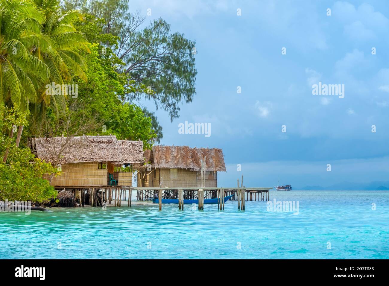 Capanne sull'acqua vicino a un'isola tropicale Foto Stock