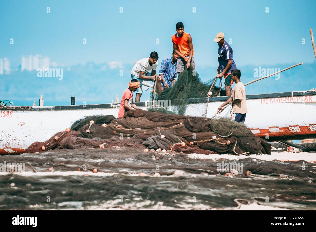 Arossim, Goa, India. Pescatori Stack Nets a riva in barca Foto Stock