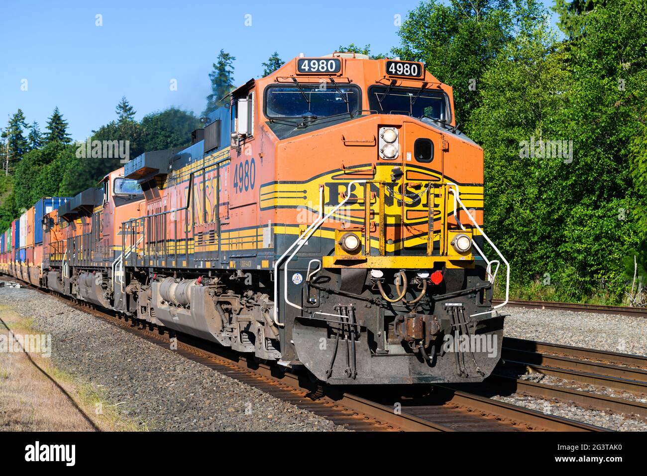 Mukilteo, WA, USA - 16 giugno 2021; chiusura del treno merci BNSF verso sud in avvicinamento a Mukilteo con una spedizione di contenitori impilati Foto Stock