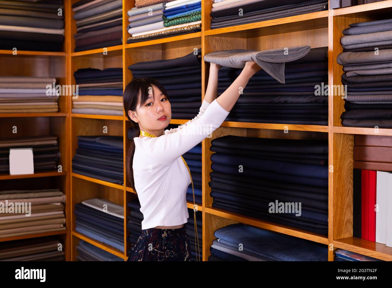 Moderna venditore cinese che lavora in negozio di tessuti Foto Stock