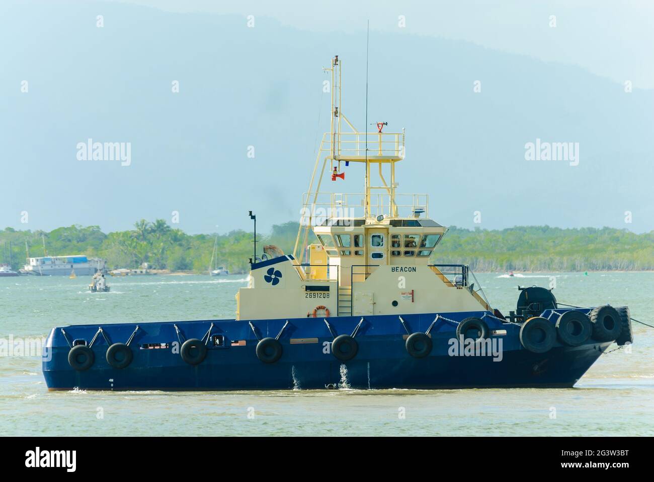 Un lato sulla vista di una barca di rimorchiatore che si manovra lungo l'insenatura di cairns nell'estremo Nord Queensland in Australia. Foto Stock