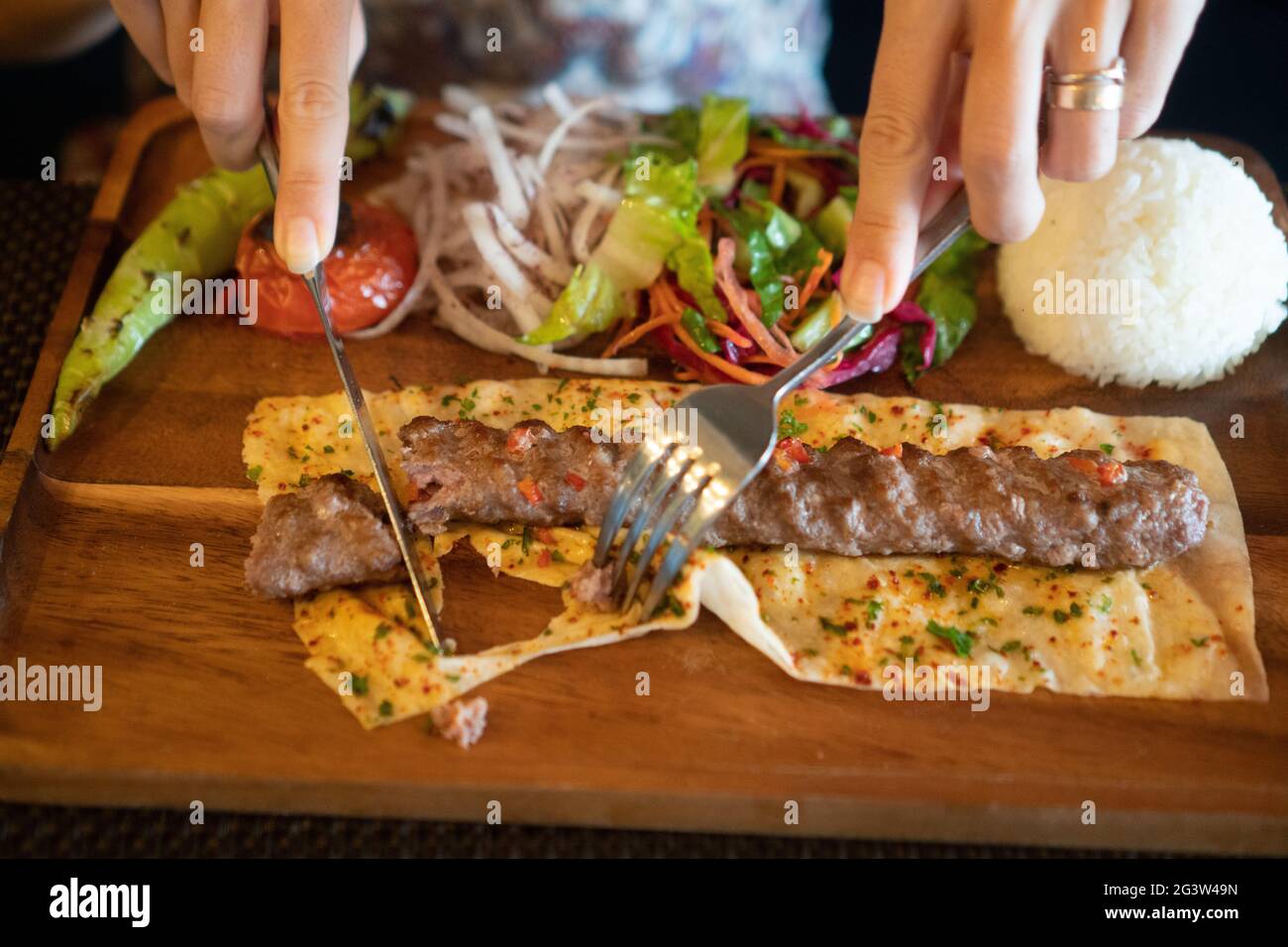 Closeup donne mani mangiare kebab in ristorante turco Foto Stock