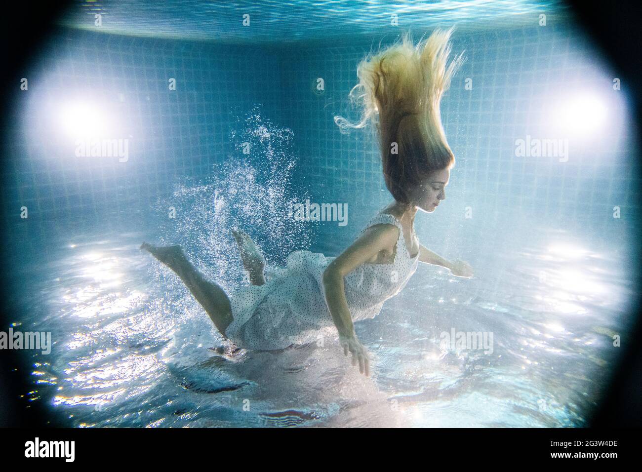 Bella donna sott'acqua in abito bianco Foto Stock