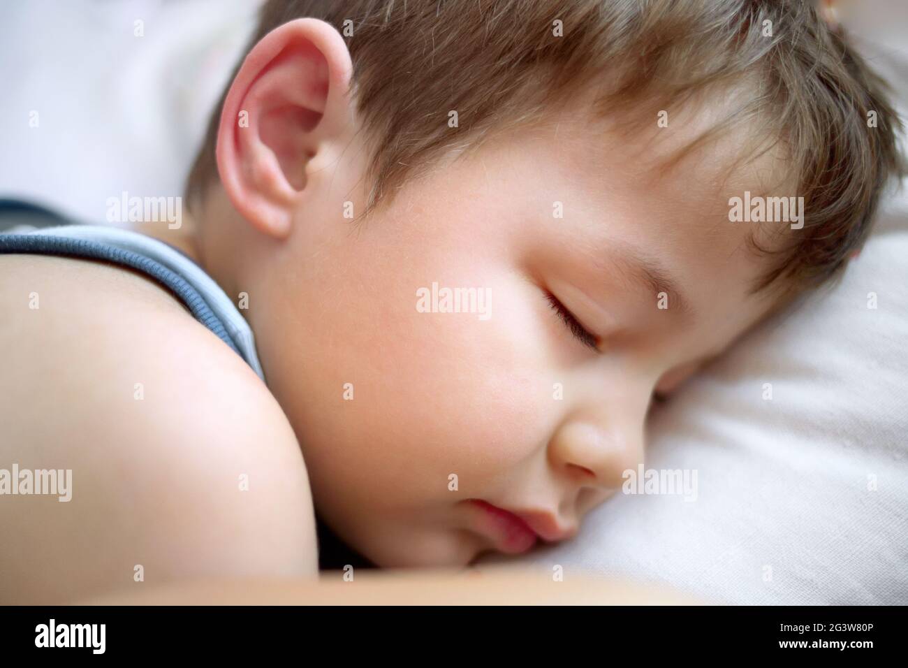 Il ragazzo sta dormendo su un cuscino bianco. Ritratto di un bambino che dorme. Foto Stock