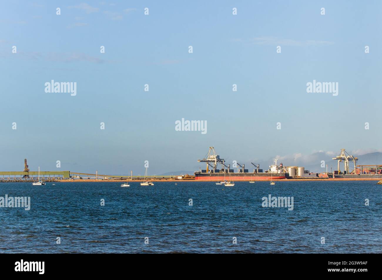 Una vista ordinata sull'orizzonte del porto marittimo di Townsville in Australia con un portarinfuse birthed e caricato in attesa di partenza. Foto Stock