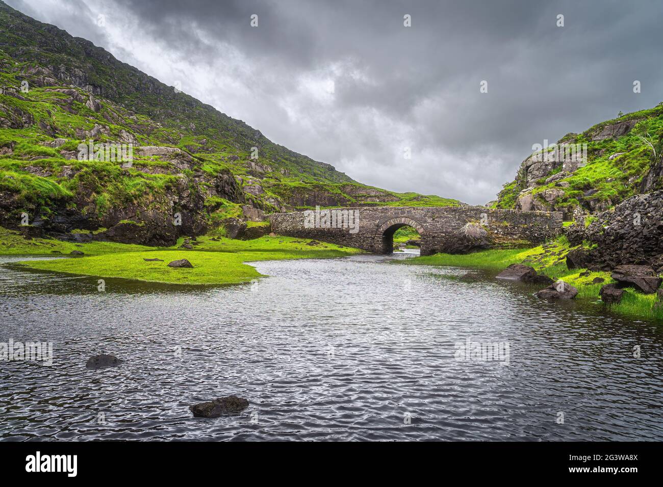 Piccolo ponte dei desideri di pietra sul lago nel Gap di Dunloe Foto Stock