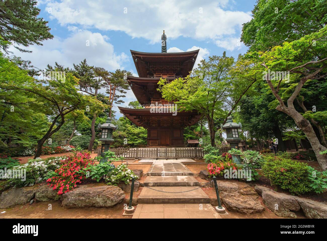 tokyo, giappone - 5 giugno 2021: Lanterne giapponesi in rame su un percorso che conduce ad una pagoda buddista a tre piani in legno nel tempio gotokuji zen noto come bir Foto Stock