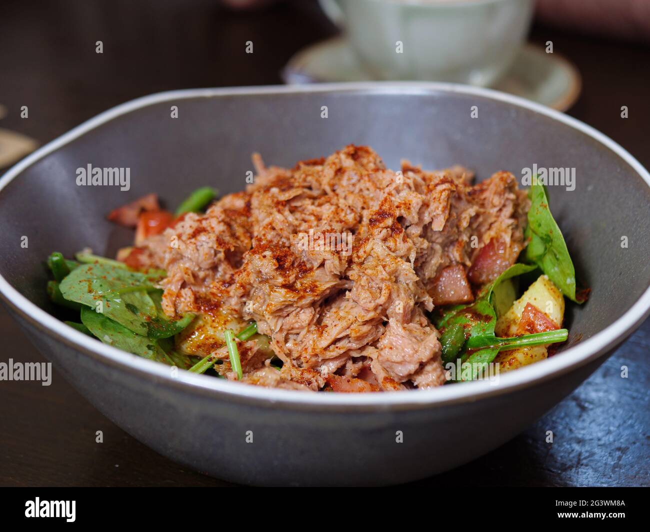 Primo piano foto di un'insalata di tonno con patate, pomodori, spinaci e fagioli verdi cosparsi di paprika affumicata Foto Stock