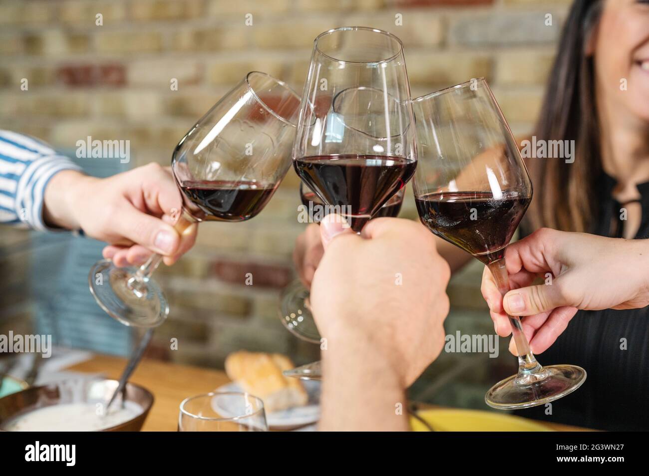 Celebrazione. Gruppo di amici che tengono i bicchieri di vino facendo un  brindisi Foto stock - Alamy