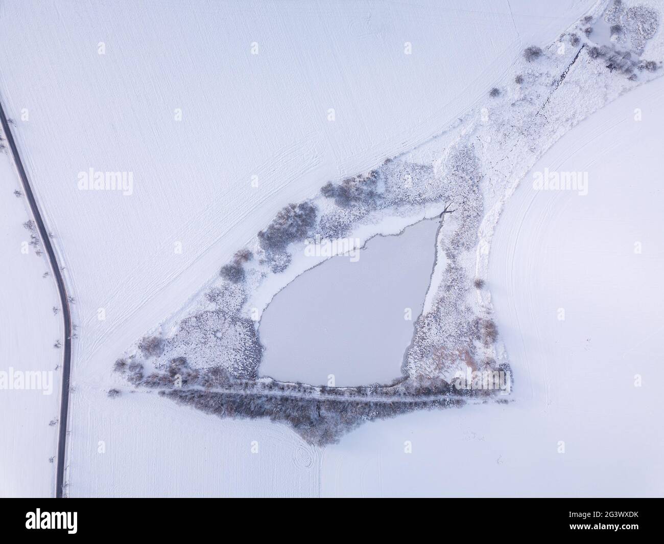 Veduta aerea di un bellissimo paesaggio invernale con laghetto ghiacciato coperto di neve. Campagna dell'europa centrale. Repubblica ceca, Foto Stock