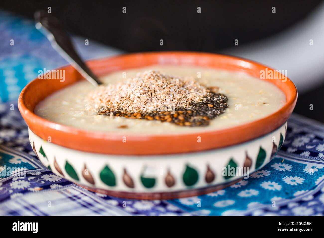 Primo piano di una colazione tradizionale - farinata d'avena con latte fatto in casa e kiwi dolce. Concetto - colazione in un caffè. Foto Stock