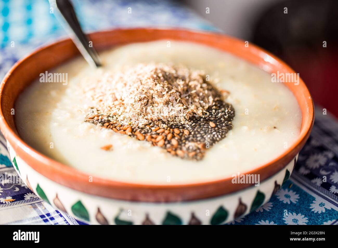 Primo piano di una colazione tradizionale - farinata d'avena con latte fatto in casa e kiwi dolce. Concetto - colazione in un caffè. Foto Stock