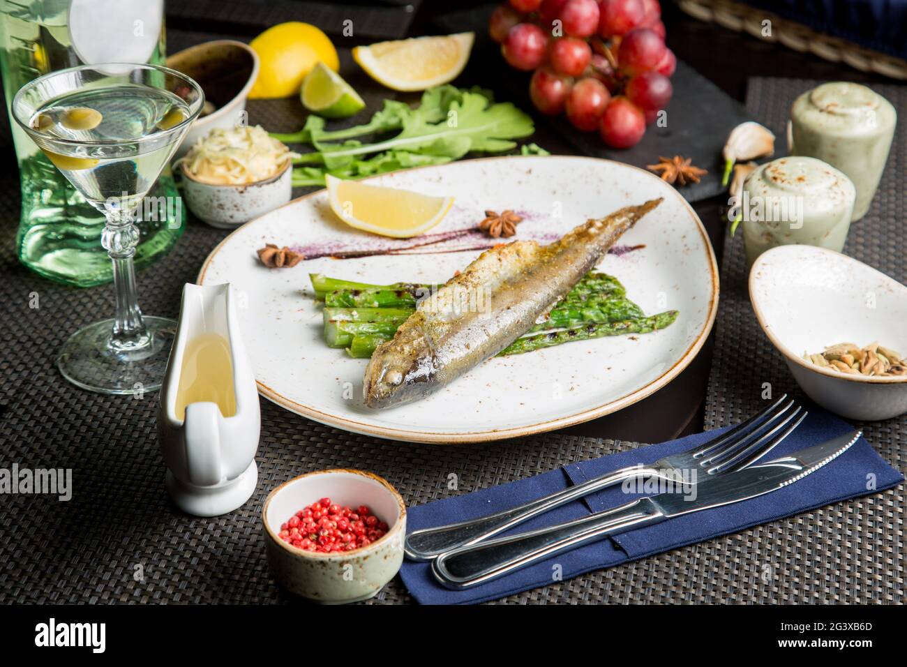 Carcassa intera di trota di mare sulla griglia. Pesce rosso fritto con verdure e salsa. Primo piano. Concetto - cibo, prelibatezze. Foto Stock
