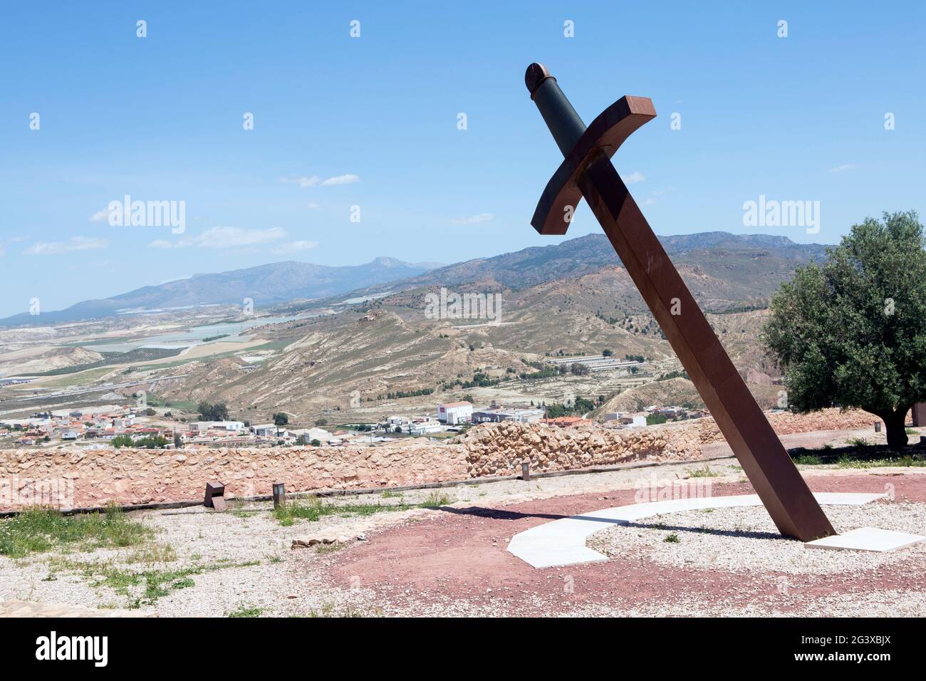 Gigantesca spada di ferro bloccata nel terreno per dare il tempo con l'ombra (meridiana) situato nel castello medievale di Lorca, Murcia, Spagna. E con un ventilatore Foto Stock