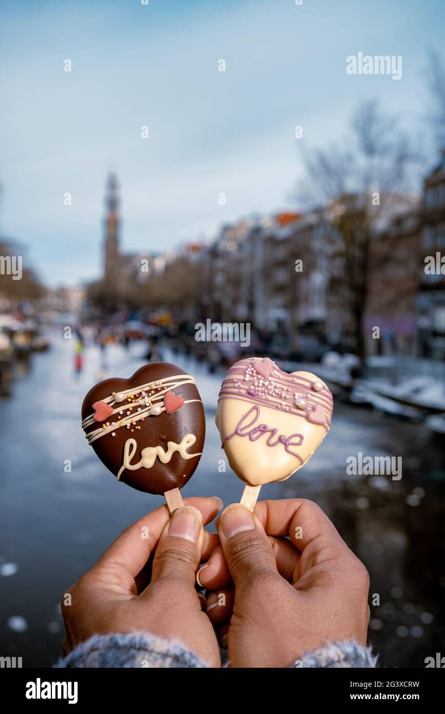 Amore romantico gelato con sullo sfondo persone pattinaggio su ghiaccio ai canali congelati di Amsterdam, Valentine Romantic concetto Foto Stock
