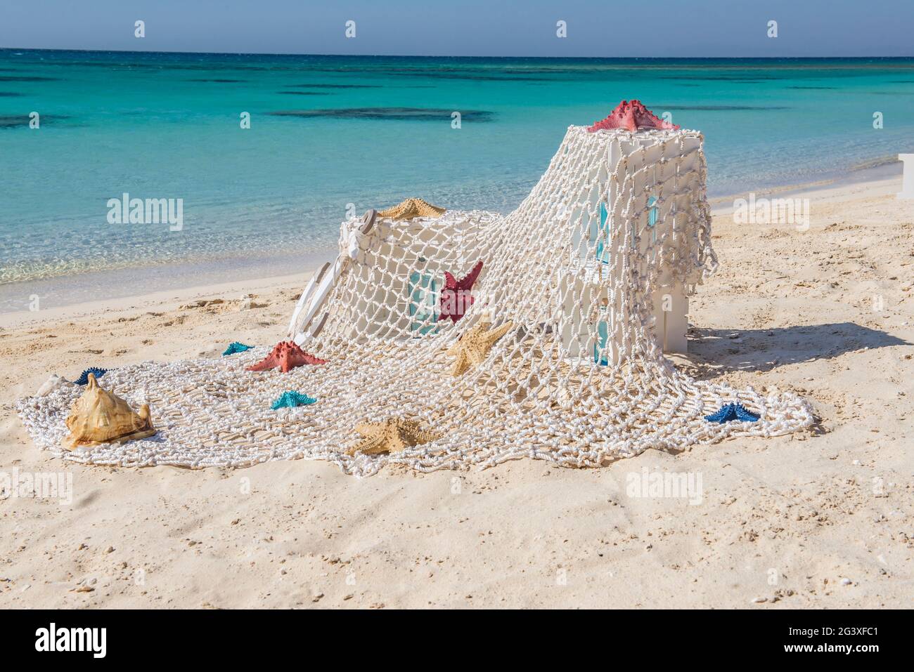 Primo piano di decorazioni romantiche di nozze sulla spiaggia di sabbia dell'isola tropicale paradiso con l'oceano sullo sfondo Foto Stock