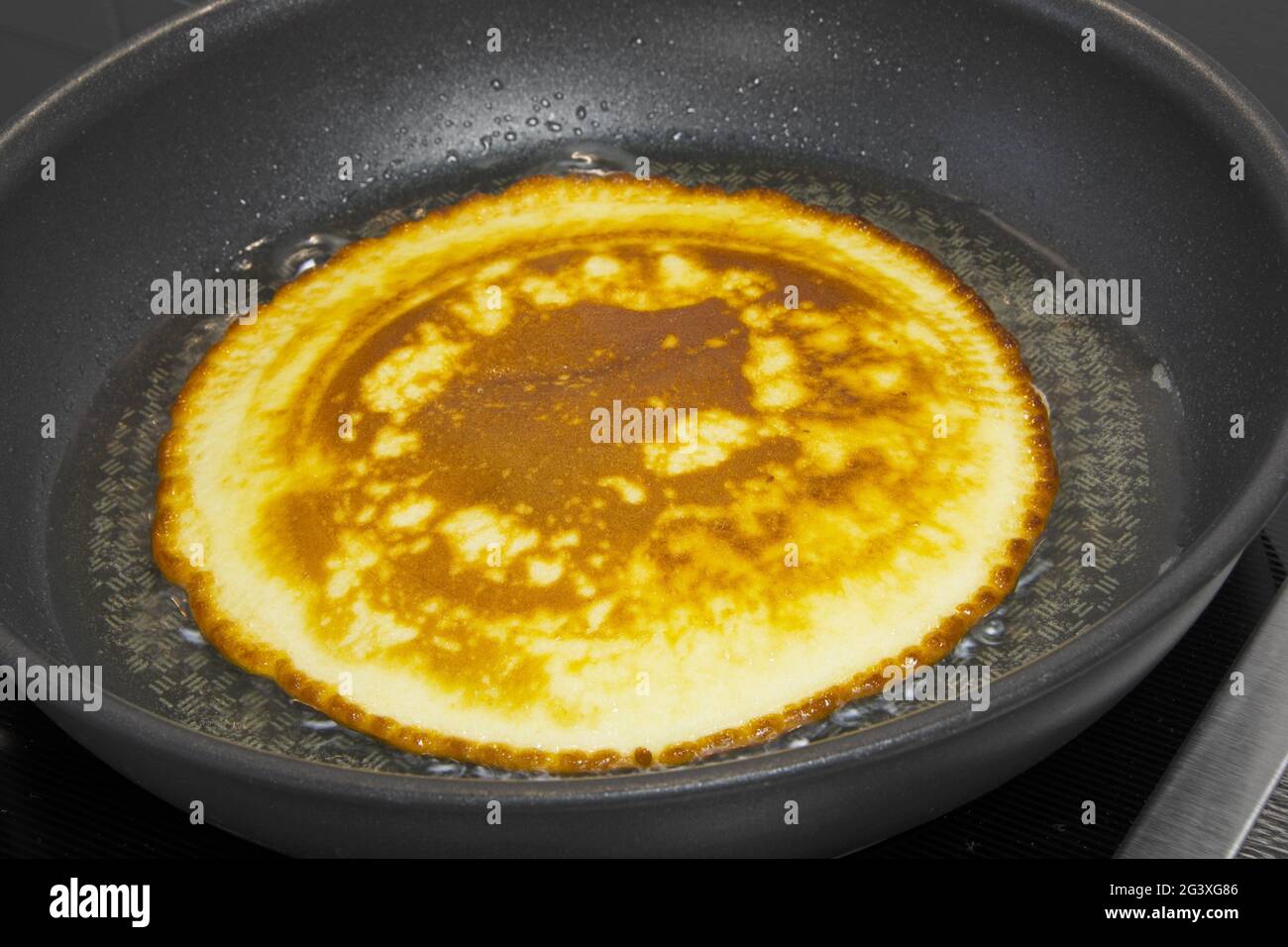 Cuocere le frittelle in una padella Foto Stock