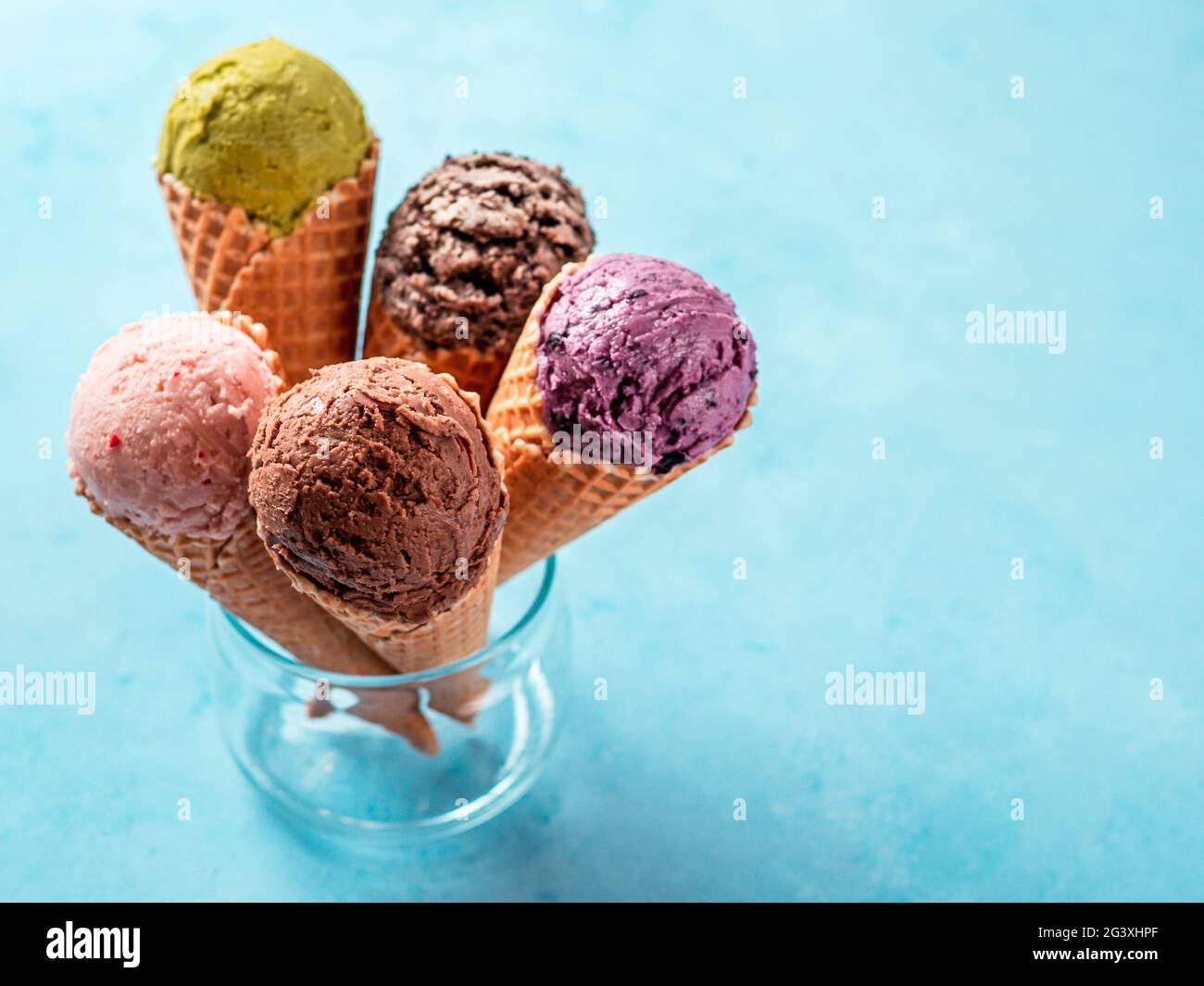 Scoop gelato in coni con spazio copia su blu Foto Stock