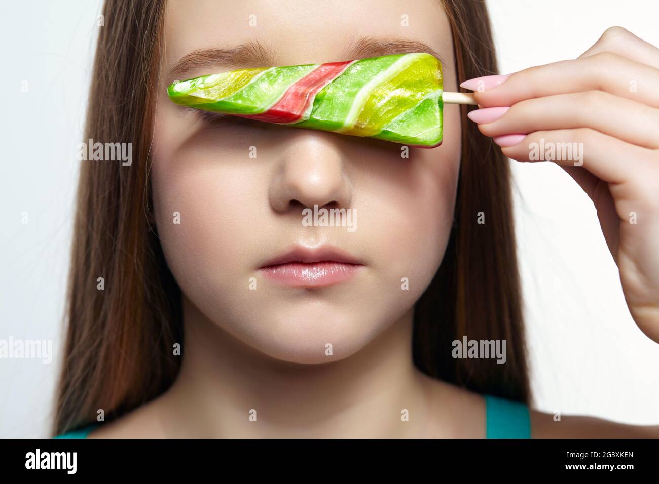Adolescente ragazza con con fiore lollipop in mani occhi di chiusura. Foto Stock