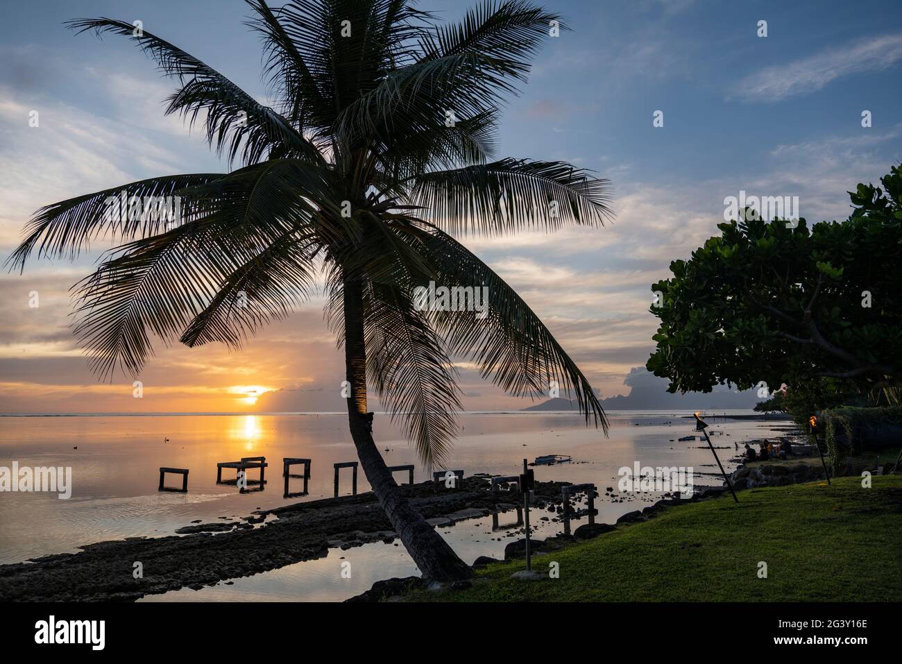 Silhouette di palme da cocco fuori dal ristorante del Tahiti Ia ora Beach Resort (gestito da Sofitel) al tramonto, vicino a Papeete, Tahiti, Windward Island Foto Stock