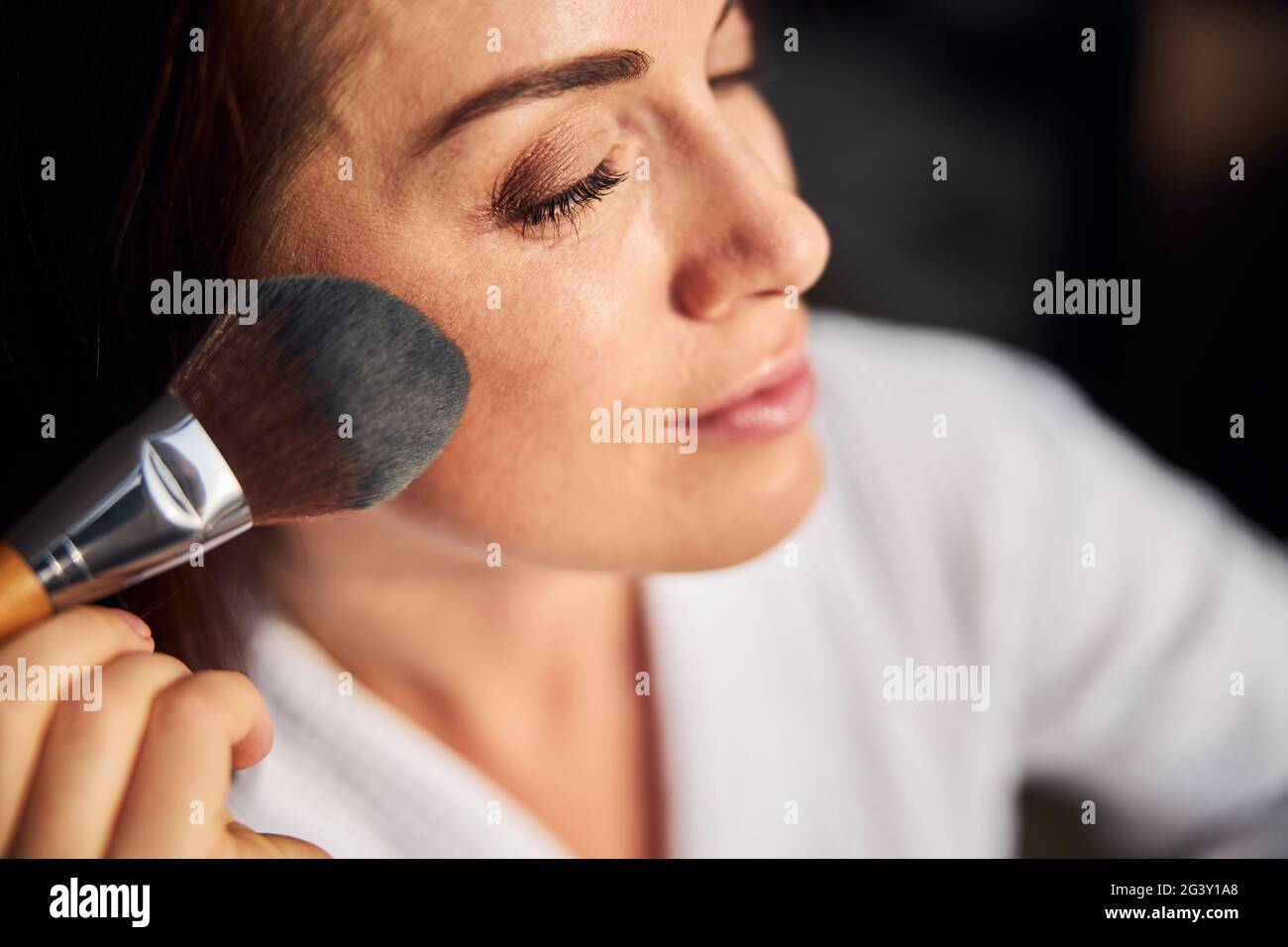 Ritratto di bella femmina che mette arrossamenti sulle guance Foto Stock