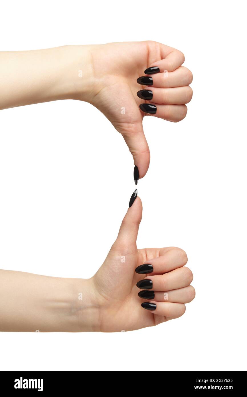 Mani femminili con unghie nere manicure con pollice su e giù isolato su sfondo bianco. Foto Stock