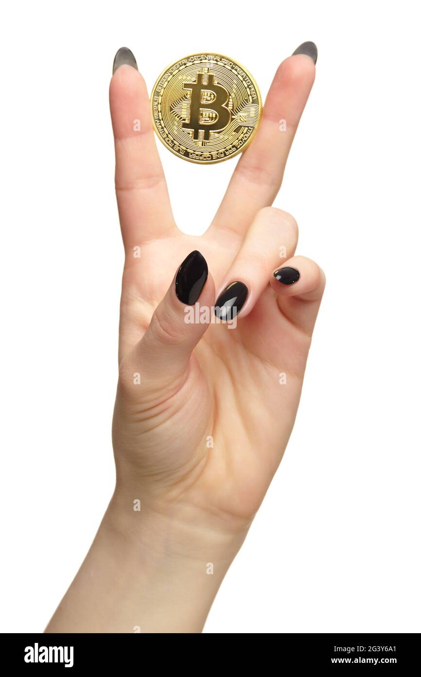 Mano femminile con unghie nere manicure e moneta d'oro in dita. Isolato su sfondo bianco. Foto Stock