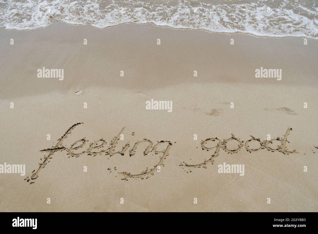 sensazione di buona scrittura a mano nella sabbia sulla spiaggia emozione sfondo Foto Stock