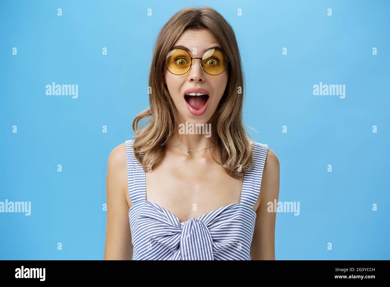 Vita-up shot di eccitato sorpresa ed emozionale carismatica caucasica donna in moda occhiali da sole apertura bocca da stupore e. Foto Stock