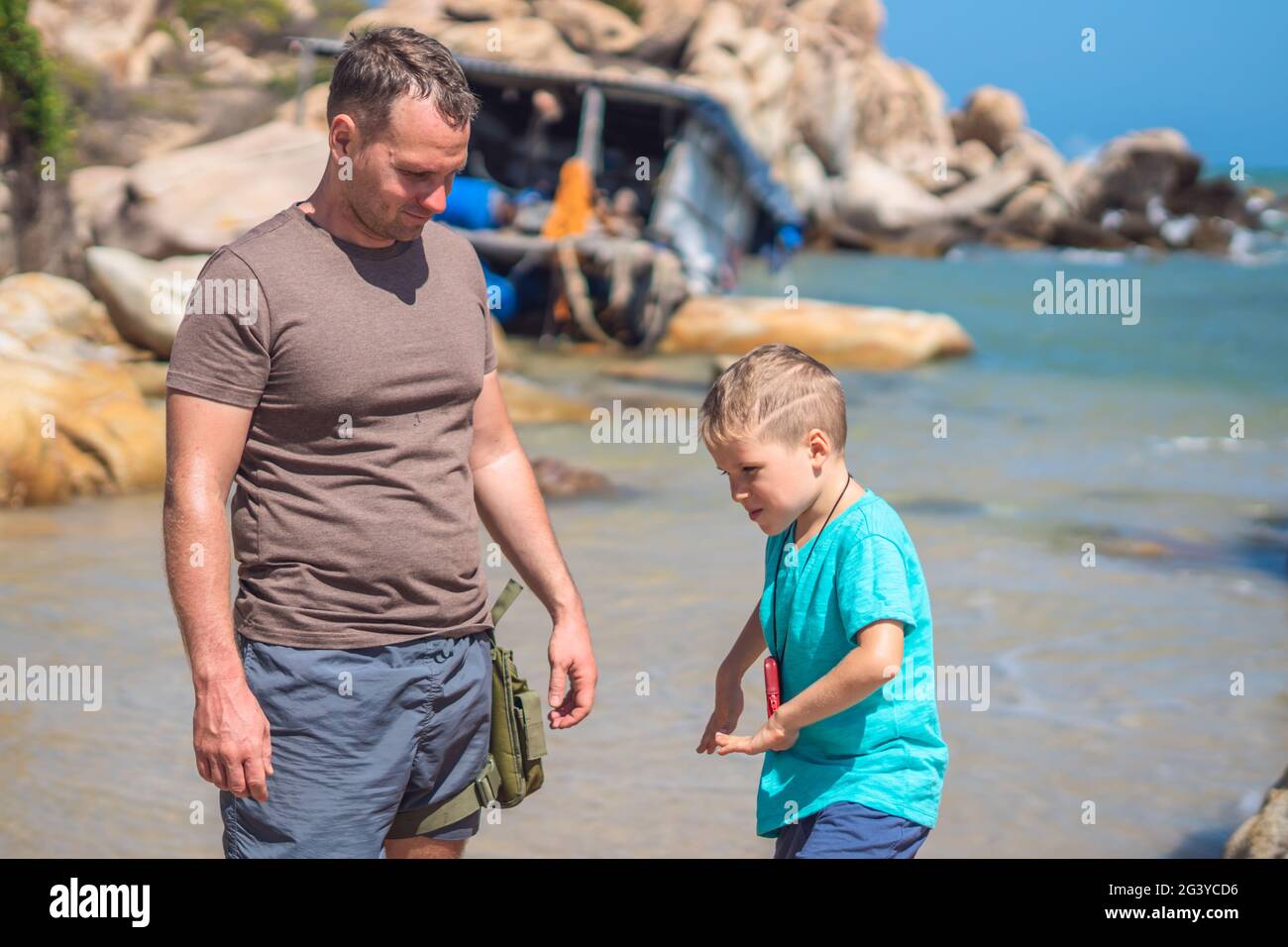 Allevare il bambino con la tecnologia della medicina alternativa. Boy Dance Play Walk utilizza un piccolo dispositivo portatile per la prevenzione dei virus del benessere in bioresonanza. Natura mare Foto Stock