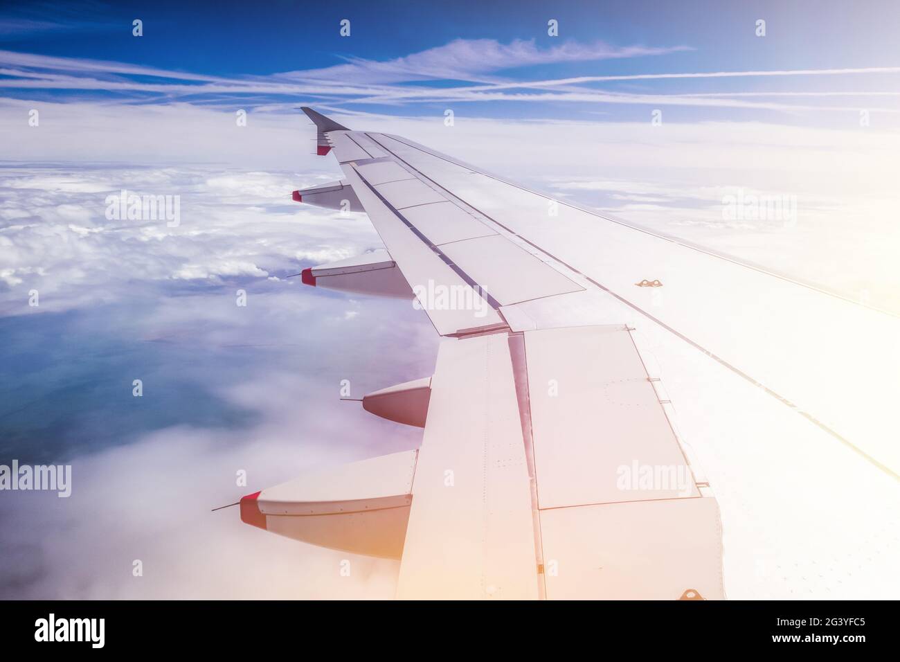 Ala dell'aereo attraverso la finestra dell'aereo. Effetto serra, riscaldamento globale. Sole. Foto Stock