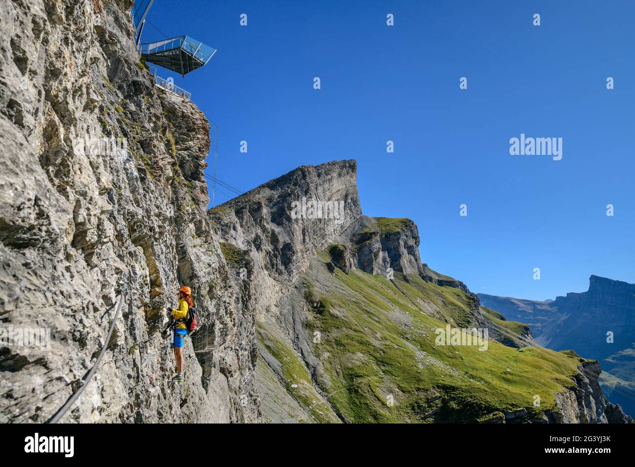 La donna sale sotto la piattaforma di osservazione dell'avventura Gemmi via ferrata, Gemmi, Alpi Bernesi, Vallese, Svizzera Foto Stock