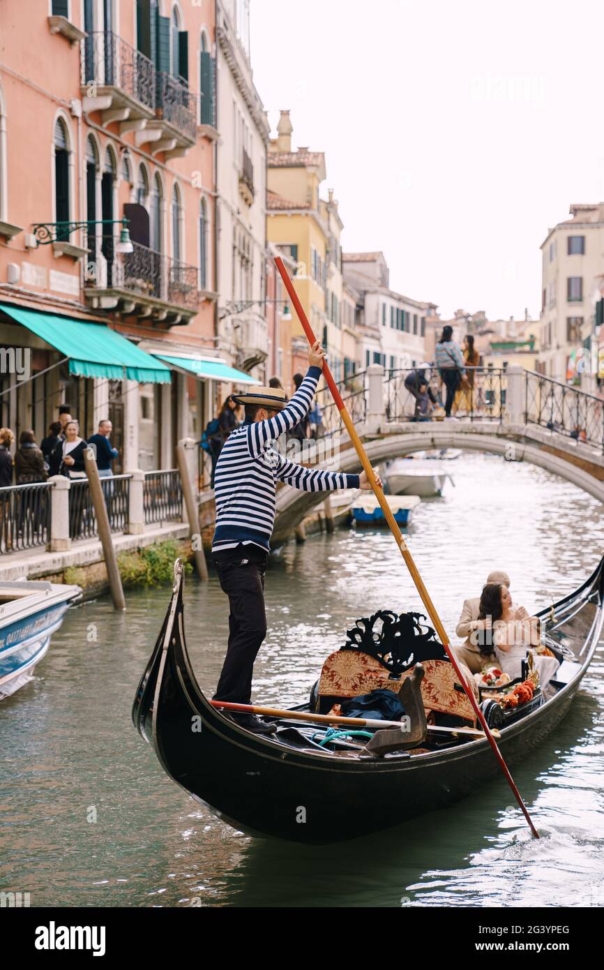 Venezia, Italia - 04 ottobre 2019: Matrimonio in Italia a Venezia. Un gondoliere rotola una sposa e uno sposo in una classica gondola di legno lungo Foto Stock