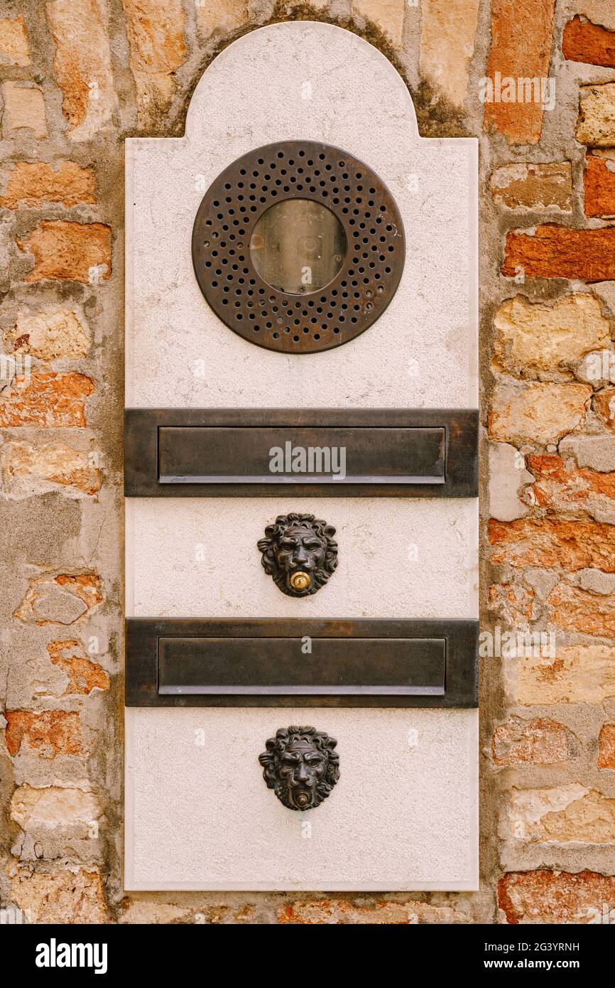 Primi piani di facciate di edifici a Venezia, Italia. Un vecchio citofono vintage e una casella postale su una parete di pietra. Sulla porta dove è stato posizionato questo Foto Stock