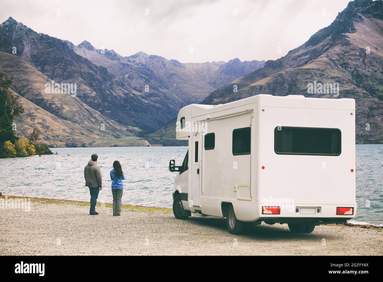 Camper camper camper van viaggio su strada giovani in Nuova Zelanda viaggio vacanza avventura, due turisti che guardano lago e montagne sulla pit stop successivo Foto Stock